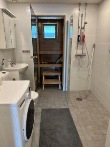 a bathroom with a washing machine and a sink at Tornio Sauna appartment 2BR in Tornio
