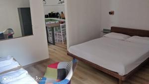 a bedroom with a bed and a chair and a kitchen at Kairos Montone in Montone