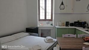 a kitchen with a bed and a table and a sink at Kairos Montone in Montone