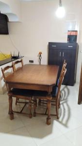 een houten tafel met 2 stoelen en een bureau bij شقة مفروشة للكراء اليومي في الناظور ليلى in Selouane