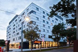 维也纳Hampton By Hilton Vienna Messe的一栋白色建筑，前面有一盏路灯