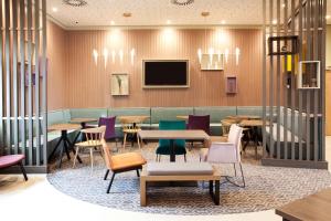 a restaurant with tables and chairs and a tv at Hampton By Hilton Vienna Messe in Vienna