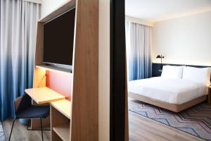 a hotel room with a bed and a flat screen tv at Hampton By Hilton Vienna Messe in Vienna
