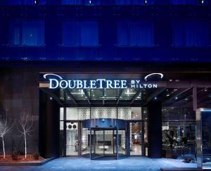 un bâtiment avec un panneau indiquant l'entrée du double arbre dans l'établissement DoubleTree by Hilton Zagreb, à Zagreb