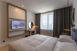 a hotel room with a bed and a tv at Hilton Garden Inn Zagreb - Radnička in Zagreb