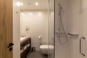 a bathroom with a shower and a toilet and a sink at Hilton Garden Inn Zagreb - Radnička in Zagreb +23 photos