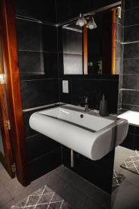 a bathroom with a white sink and black walls at Seafront Two Bedroom Apartment in St Julian's