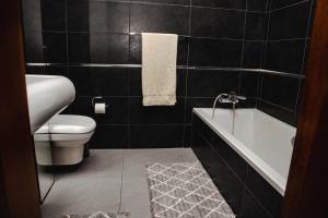 a bathroom with a white tub and a toilet at Seafront Two Bedroom Apartment in St Julian's