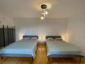 a bedroom with two beds and a light fixture at Apartament przy Atrium okolice stacji metra Rondo ONZ in Warsaw