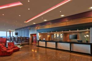 a hotel lobby with a bar and a red chair at Hilton Zurich Airport in Opfikon