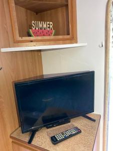 a computer monitor and a remote control sitting on a counter at Tropikalny Zakątek in Sarbinowo