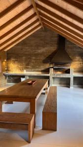 una cocina con una mesa de madera y una estufa en hermoso departamento 1 dormitorio en entorno natural, en Pucón 21 fotos más