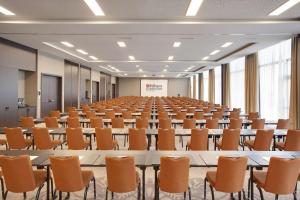 uma grande sala com fileiras de mesas e cadeiras em Hilton Garden Inn Zurich Limmattal em Spreitenbach