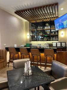 a restaurant with a bar with chairs and a table at Best Western Plus Chihuahua Juventud in Chihuahua