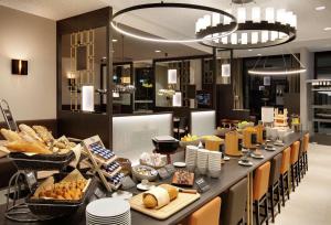ein Buffet mit Brot und Gebäck darauf in der Unterkunft Hilton Garden Inn Zurich Limmattal in Spreitenbach