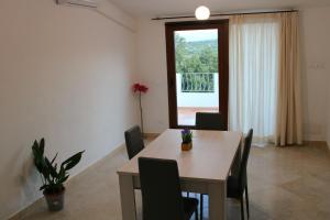 una sala da pranzo con tavolo, sedie e una finestra di Casa Bel Panorama a Orosei