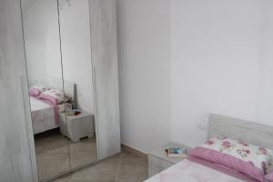 a bedroom with a mirror and a bed with pink sheets at Casa Bel Panorama in Orosei
