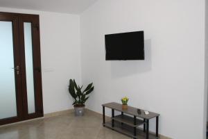 un soggiorno con tavolo e TV a parete di Casa Bel Panorama a Orosei
