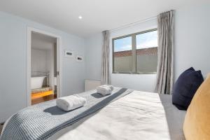 a bedroom with a bed with two towels on it at Linger Lakeside in Taupo