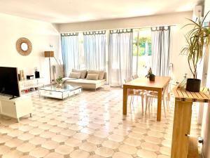 uma sala de estar com um sofá e uma mesa em Appartement 3P 88 m2 terrasse et jardin à 20 metres de la plage em Antibes