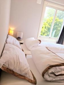 dwa łóżka w pokoju z oknem w obiekcie Modern central apartment next to beautiful nature2424 w Oslo