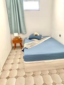 um quarto com uma cama com lençóis azuis e uma janela em Appartement 3P 88 m2 terrasse et jardin à 20 metres de la plage em Antibes