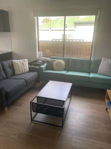 a living room with a blue couch and a table at Milton House, Hamilton in Hamilton