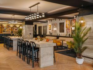 un restaurant avec un bar et des chaises jaunes dans l'établissement Marty Hotel Bordeaux - Tapestry Collection by Hilton, à Bordeaux