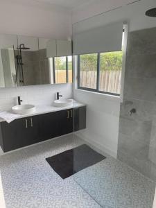 a bathroom with two sinks and a glass shower at Milton House, Hamilton in Hamilton