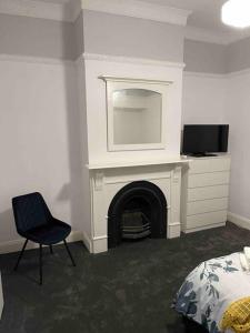a bedroom with a fireplace and a bed and a chair at Milton House, Hamilton in Hamilton