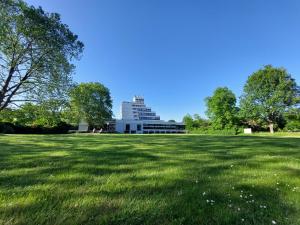 ein großes Grasfeld mit einem Gebäude im Hintergrund in der Unterkunft Heinrich Pesch Hotel in Ludwigshafen am Rhein