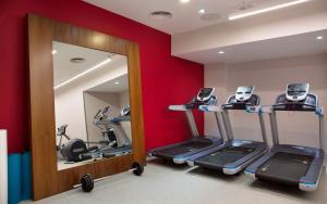 a fitness room with tread machines and a mirror at Hilton Garden Inn Ufa Riverside in Ufa