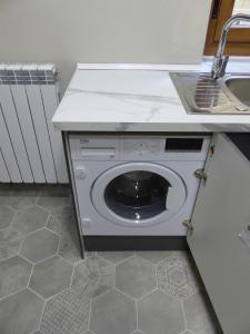 una lavadora en una cocina con fregadero en Apartamento Ábside de San Juan I, en Estella