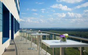 a balcony with tables and a vase of flowers on it at Hilton Garden Inn Ufa Riverside in Ufa