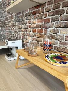 a wooden table in front of a brick wall at Mariamora Apartment in Bari