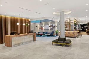 a lobby with a waiting area with chairs and tables at Hilton Garden Inn Riga Old Town in Rīga