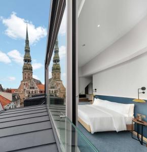 a bedroom with a bed and a view of the city at Hilton Garden Inn Riga Old Town in Rīga