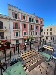a balcony with a wooden bench and a building at Mariamora Apartment in Bari