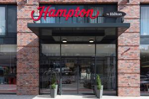 a store front with a sign on a brick building at Hampton By Hilton Hamburg City Centre in Hamburg