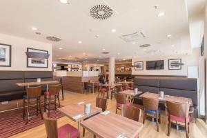 a restaurant with tables and chairs and a bar at Hampton By Hilton Hamburg City Centre in Hamburg