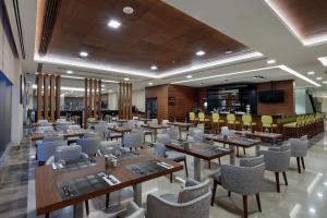 um restaurante com mesas e cadeiras num quarto em Hilton Garden Inn Corlu em Çorlu