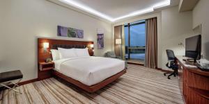 een hotelkamer met een bed, een bureau en een televisie bij Hilton Garden Inn Corlu in Corlu
