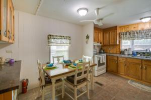 cocina con mesa de madera y sillas y cocina con fregadero en Satsuma Vacation Rental with Dunns Creek Access en Satsuma