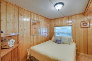 1 dormitorio con 1 cama en una habitación con paneles de madera en Satsuma Vacation Rental with Dunns Creek Access, en Satsuma