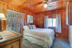 a bedroom with a bed in a wooden room at Furnished Porch and Gas Grill Lakeside Cottage Stay in Pinetop-Lakeside
