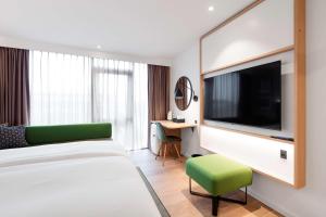a hotel room with a bed and a flat screen tv at Hilton Garden Inn Faroe Islands in Tórshavn