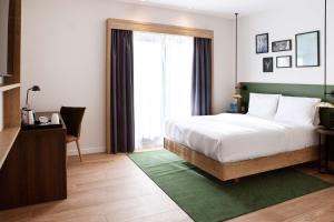 a bedroom with a bed and a large window at Hilton Garden Inn Munich Messe in Feldkirchen +218 photos