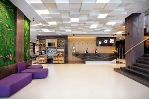 un hall d'un magasin avec des meubles violets dans l'établissement Hilton Garden Inn Tirana, à Tirana