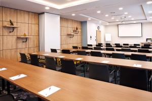 a conference room with tables and chairs and a screen at Hilton Garden Inn Munich Messe in Feldkirchen