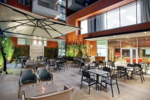 un restaurant avec des tables et des chaises dans un bâtiment dans l'établissement Hilton Garden Inn Tirana, à Tirana